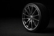 24-inch aftermarket rim positioned deep on far right, 575x383px, black asphalt background